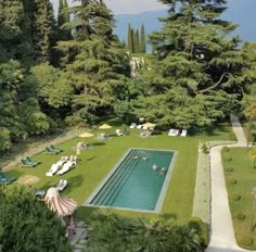 an aerial view of a pool surrounded by trees