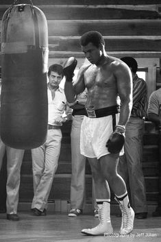 a man standing next to a punching bag