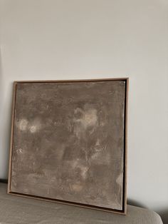 a painting sitting on top of a bed next to a wall