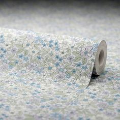 a roll of toilet paper with blue and green floral designs on it's side