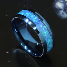 a black ceramic ring with blue opal inlaying the center and glow inside