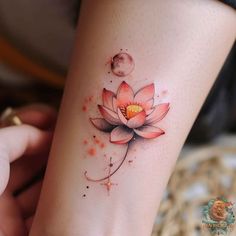 a woman's leg with a flower tattoo on the side of her arm and moon in the background