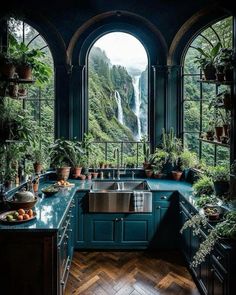 a kitchen with an arched window and lots of potted plants