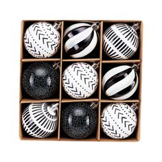 twelve black and white ornaments in a cardboard box