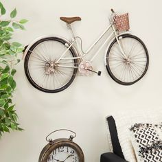 a white bicycle mounted to the side of a wall next to a chair and clock