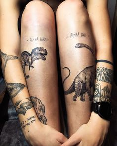 two people with tattoos on their legs sitting next to each other