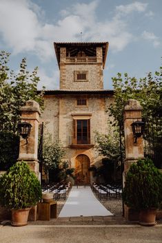 the entrance to an old stone building with tables and chairs set up for a wedding