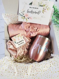 a pink gift box filled with personalized coffee mugs and other gifts for bridesmaids