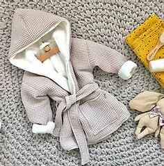 a baby's bathrobe and other items laid out on a carpeted area