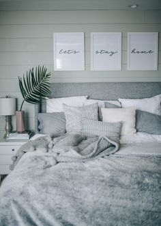 a bed with two framed pictures above it and a blanket on top of the bed