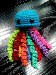 a small crocheted octopus sitting on top of a wooden table