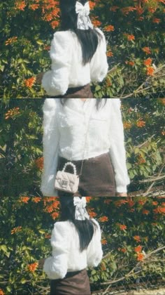 a woman standing in front of flowers wearing a white jacket and brown skirt with her hands on her hips