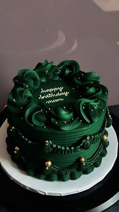 a green cake with gold decorations on top