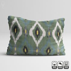 a green and yellow pillow with an abstract design on the front, sitting against a white background