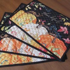 three quilted place mats with pumpkins on them