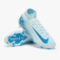 a pair of white and blue nike soccer cleats on a white background,