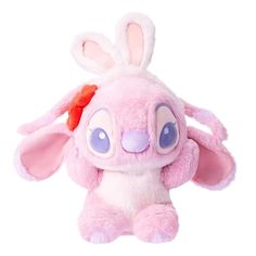 a pink stuffed animal with blue eyes and ears