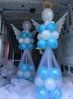 balloons in the back of a van with angel wings on them and blue and white balls