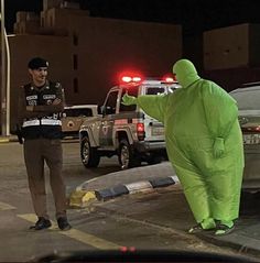 a man in a green costume standing next to another man