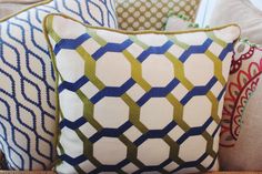 four pillows are sitting on a couch with different colors and patterns in the same pattern