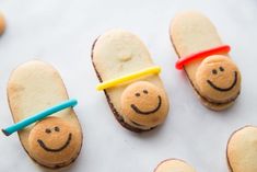 some cookies shaped like people with faces on them and one has a toothbrush in his mouth