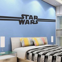 a bed room with a neatly made bed and a star wars decal on the wall