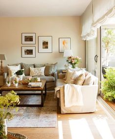 a living room filled with lots of furniture and flowers in vases on the windowsill