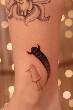 a tattoo on the leg of a woman with a cat and moon above her head