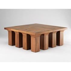 a square wooden table with four columns on each side and one column at the end