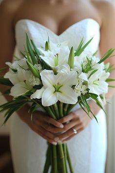 a bride holding a bouquet of white flowers