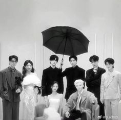 a group of people standing next to each other holding an umbrella