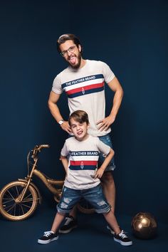 a man standing next to a little boy in front of a bike and soccer ball