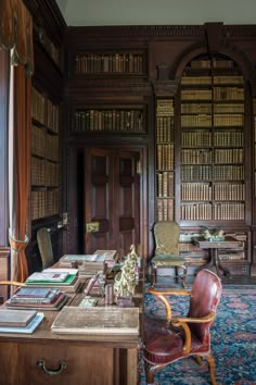 an old library with many books on the shelves and leather chairs in front of it