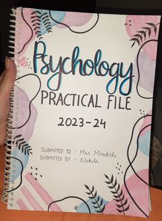 a hand holding a notebook with the words psychology practical file on it