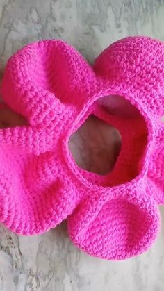 a pair of pink crocheted slippers sitting on top of a table