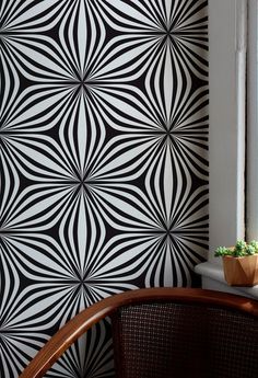 a room with black and white wallpaper, potted plant on the window sill