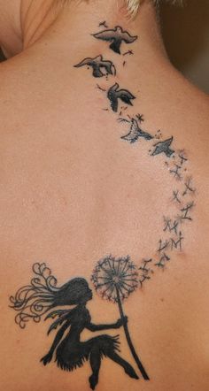 a woman with a dandelion tattoo on her back is looking at birds flying in the sky