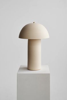 a white sculpture with a mushroom on top