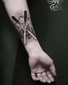 a person's arm with skis and trees on it