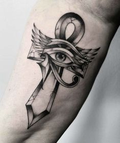 an eye and cross tattoo on the arm