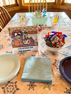 the table is set up for a children's birthday party with paper plates and napkins