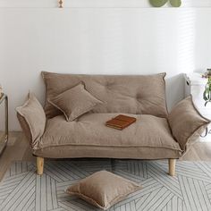 a brown couch sitting on top of a wooden floor