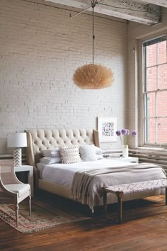 a bedroom with white brick walls and furniture