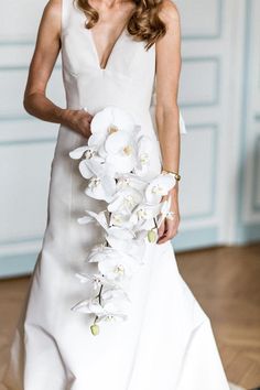 a woman in a white dress holding a bouquet of flowers