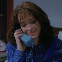 a woman talking on a phone while sitting in bed