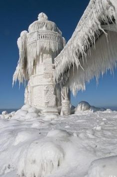 an ice covered fire hydrant with icicles on it's sides and the sky in the background