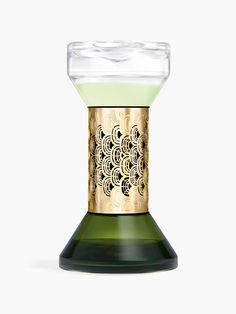 a green and gold candle holder with an intricate design on the top, in front of a white background