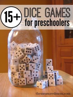 a jar filled with dice sitting on top of a wooden table