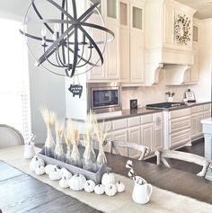 a dining room table with vases on it and a chandelier hanging from the ceiling