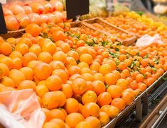 an assortment of oranges and other fruits on display in a grocery store's produce section